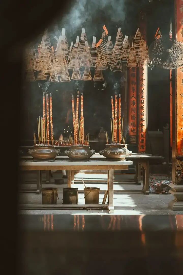 Candles and incense glowing in a Vietnamese temple